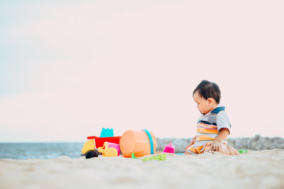 Boy toy on beach against sky