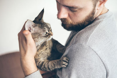 Man with beard stroking cat