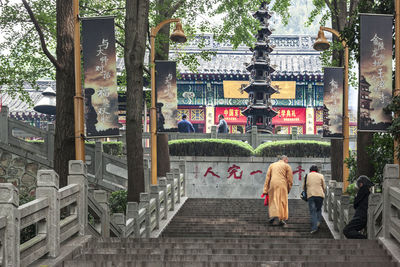 Rear view of people walking in front of building