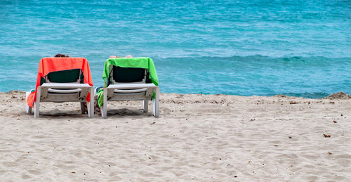 Lounge chairs on shore at beach
