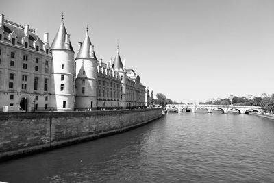 View of buildings by river against clear sky paris palace of justice 