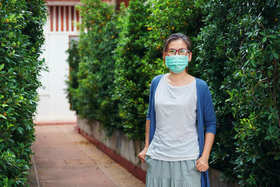 A woman wears a mask in a public park when going outdoor during covid-19 pandemic