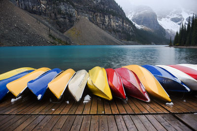 Multi colored pencils by lake against sky