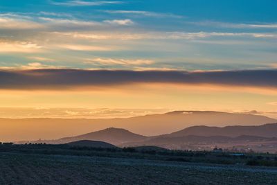 Scenic view of field against sky during sunset