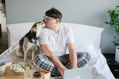 Side view of woman using laptop while sitting on sofa at home