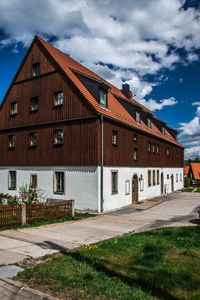 Houses by street against sky