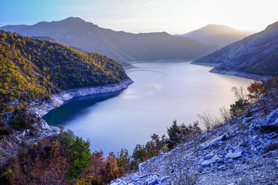 Scenic view of lake and mountains against sky