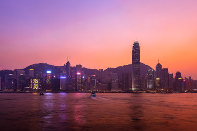 Illuminated buildings against sky during sunset