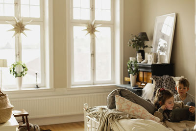 Girl using digital tablet on sofa