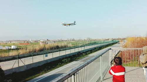 Airplane on runway against clear sky