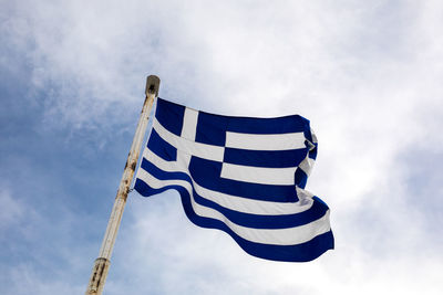 Low angle view of flag against blue sky