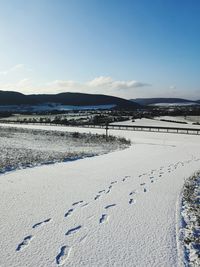 Scenic view of snow covered land against sky