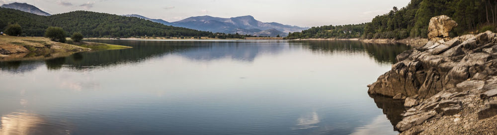 Scenic view of river amidst mountains against sky