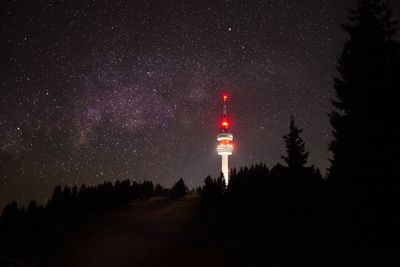 Illuminated tower against sky at night