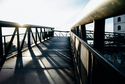 Railing by sea against sky on sunny day