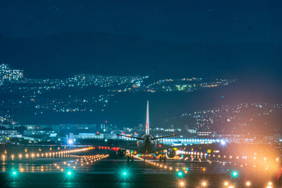 Illuminated cityscape against sky at night