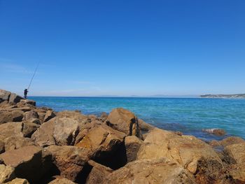Scenic view of sea against clear blue sky