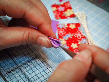 Cropped hands making fabric artwork at table