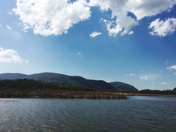 Scenic view of lake and mountains against blue sky