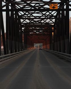 Empty road along bridge in city