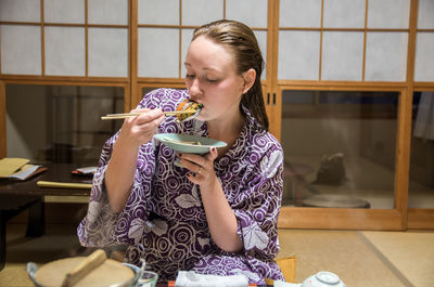 Young woman eating japanese food