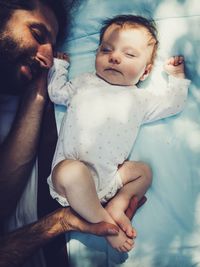 Full length of father with baby on bed