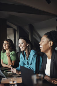 Female entrepreneurs laughing during business meeting at office