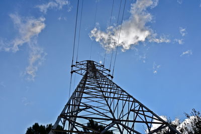 Low angle view of cranes against blue sky