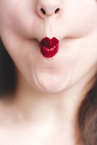 Cropped image of woman with red lipstick puckering