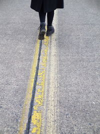 Low section of woman walking on road