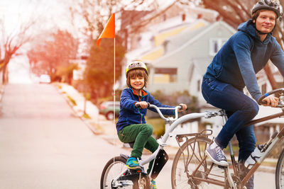 Portrait of son riding bicycle with father