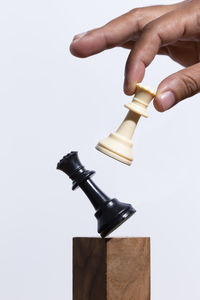 Cropped hand of person holding hammer against white background