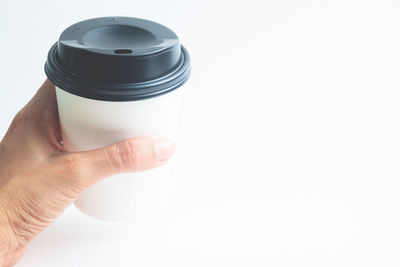 Close-up of hand holding camera over white background