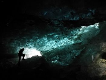 Silhouette of person standing in cave