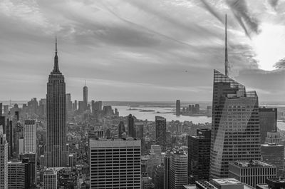 Modern buildings in city against cloudy sky