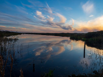 Scenic view of lake against sky at sunset