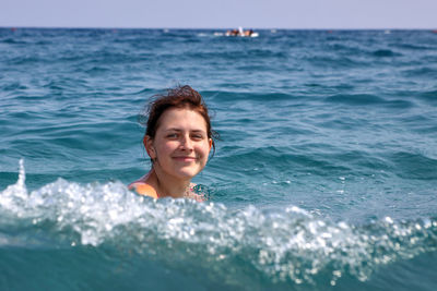 Portrait of young woman swimming in sea