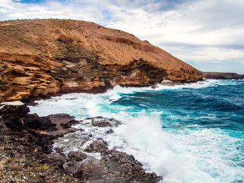 Scenic view of sea and mountains against sky