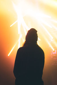 Rear view of silhouette man standing at sunset