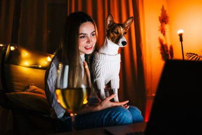 Portrait of smiling young woman sitting at home