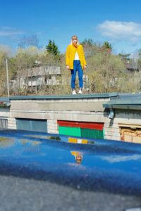 Man standing by swimming pool against blue sky