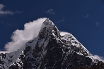 Low angle view of snowcapped mountain against sky