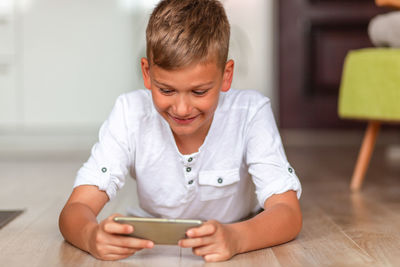 Boy sitting on mobile phone at home