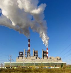 Smoke emitting from chimney against blue sky