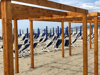 Wooden posts on beach against sky