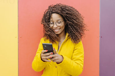 Portrait of smiling young woman using smart phone