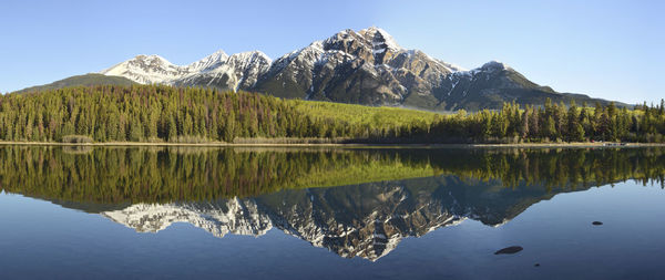 Scenic view of lake and mountains against clear blue sky