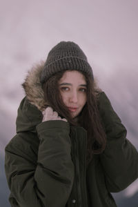 Portrait of young woman standing in snow