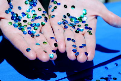 Close-up of woman hand holding sequins