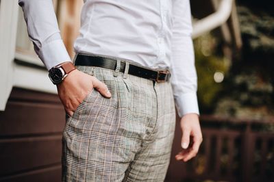 Midsection of well-dressed man standing in park